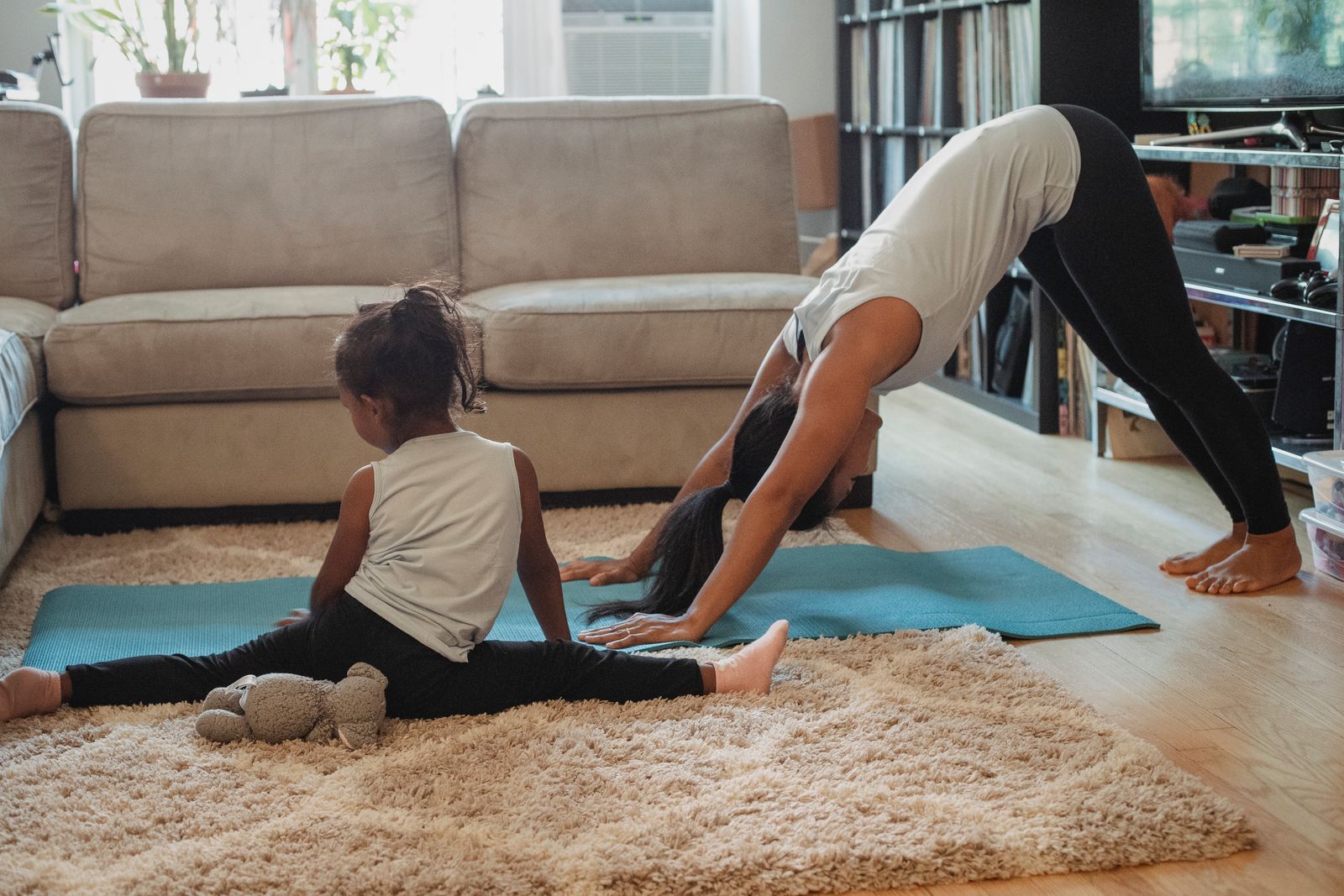 Mother and young child stretching together at home during a gentle postpartum yoga session