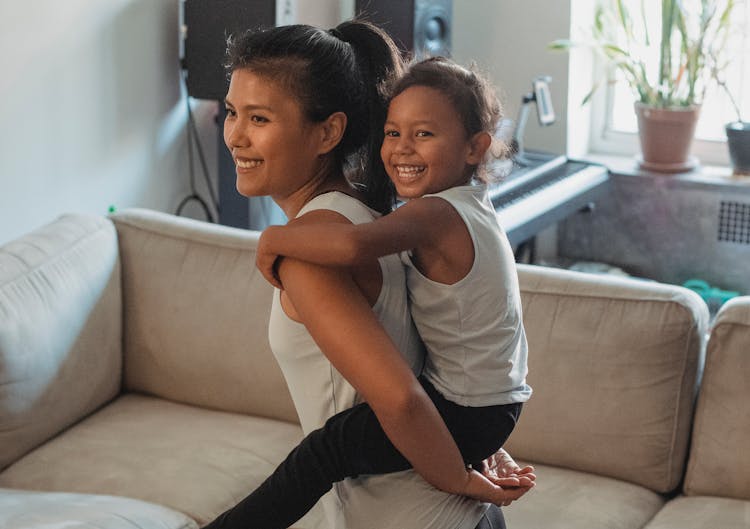 Happy Woman Carrying Child On Back