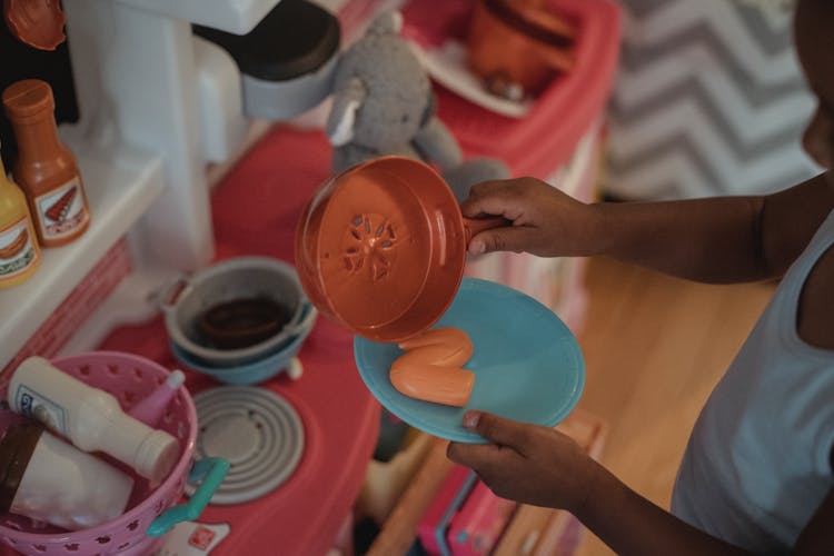 Anonymous Child Playing With Toy Kitchen