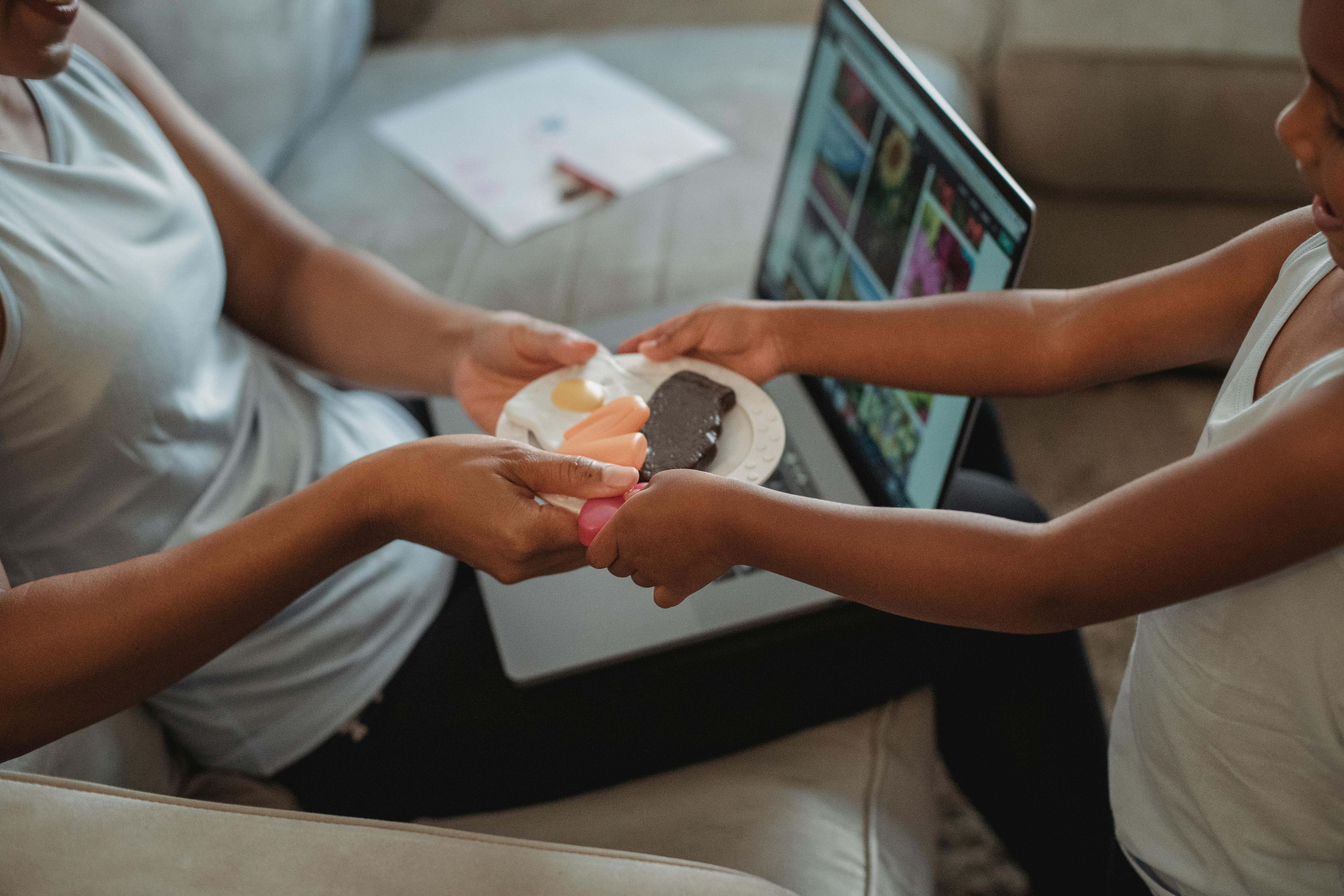 crop mother and daughter with plate of sweets