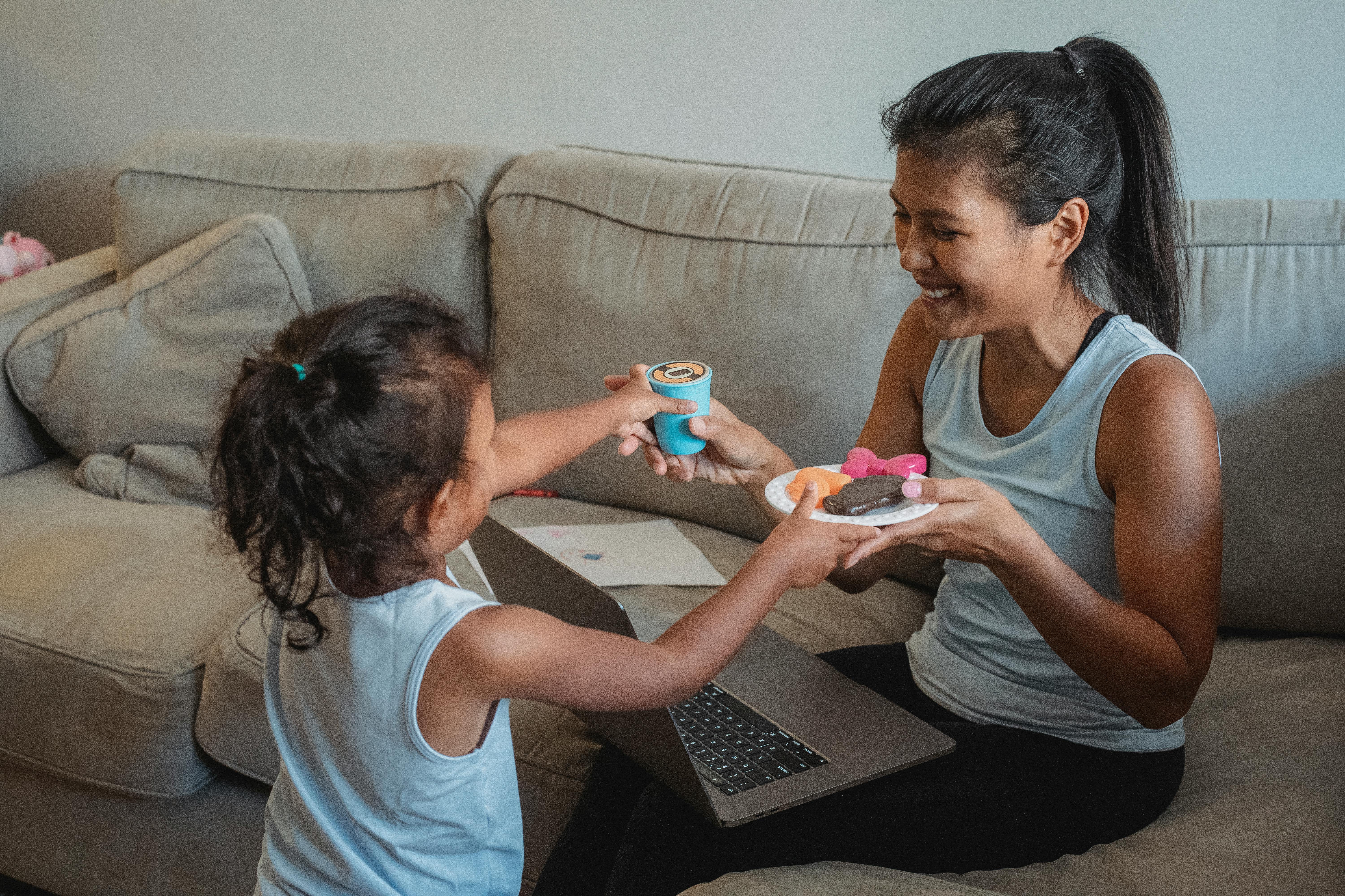 cheerful mother and daughter with toy sweets