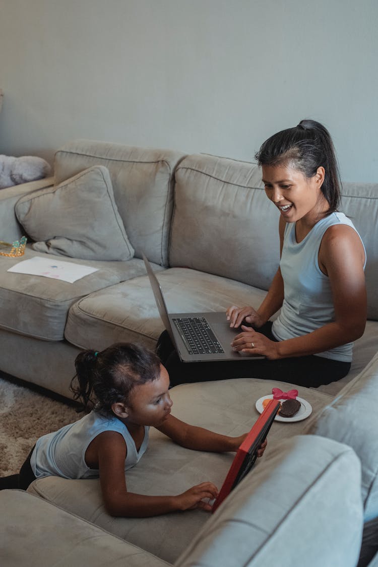 Ethnic Woman With Laptop Looking At Daughter