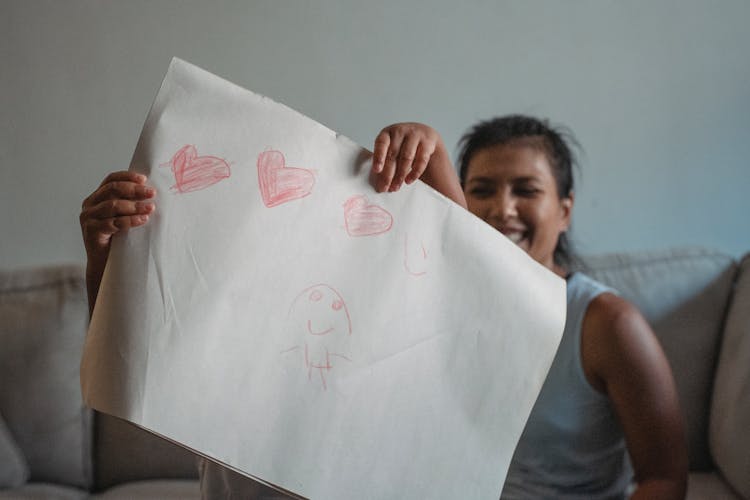 Ethnic Woman With Daughter Showing Drawing