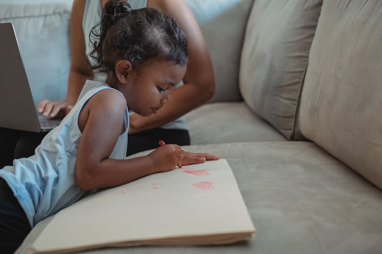 Concentrated Ethnic Girl Drawing On Paper