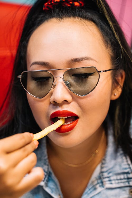 A young Woman Eating Fries