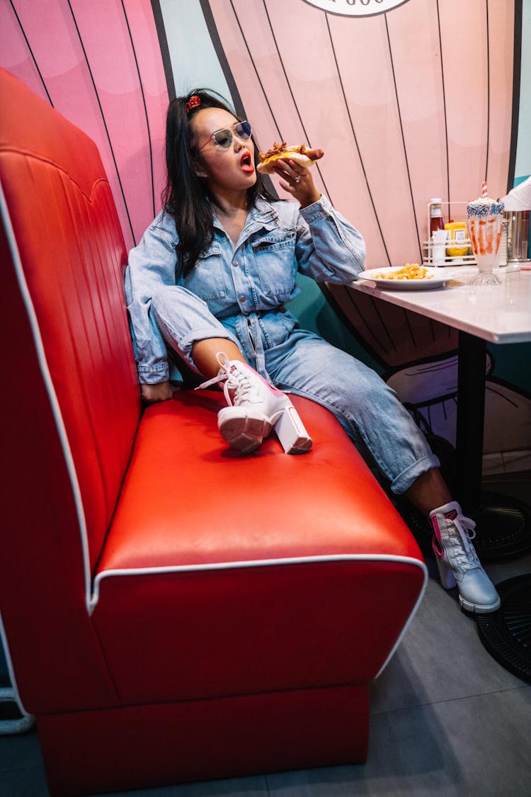 A Woman Eating A Hotdog Sandwich