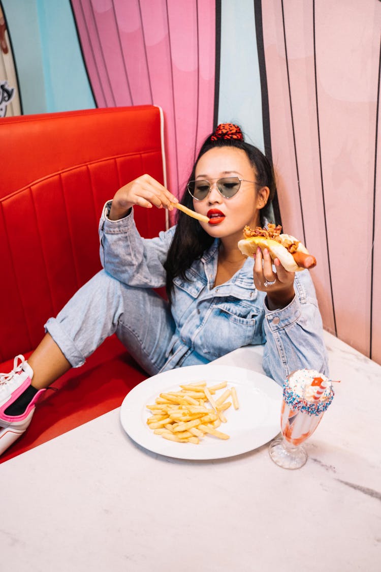 Woman In Denim Jacket Eating Fries 