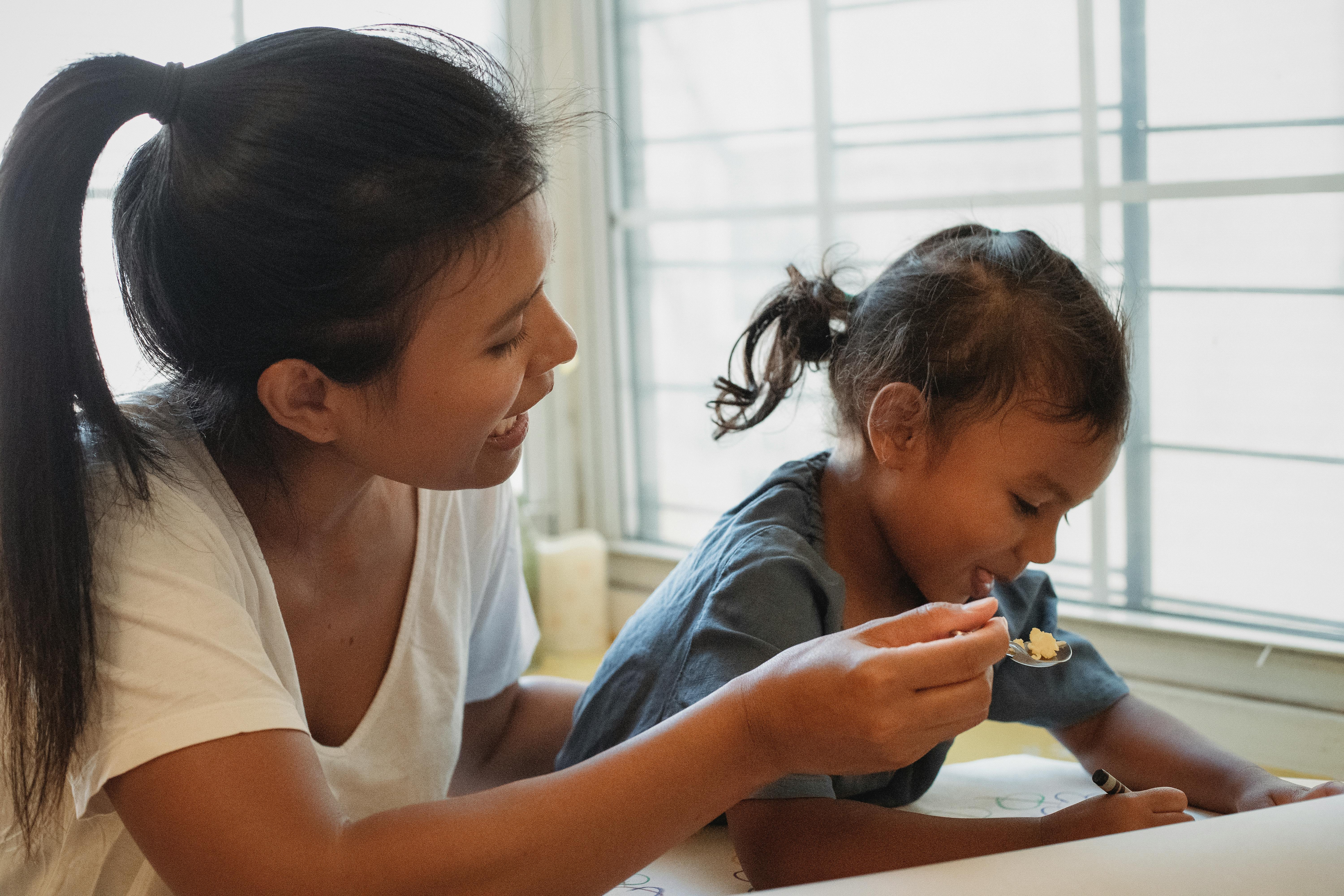 mother feeding child at table