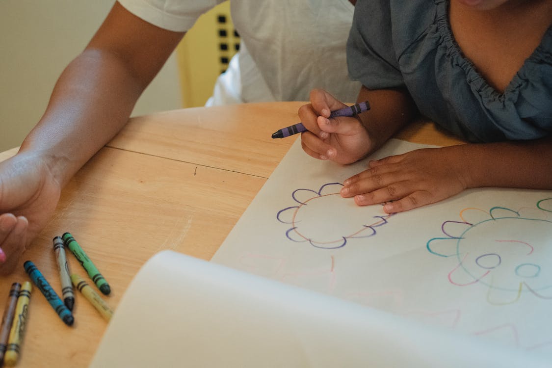 Crop parent and child drawing at table