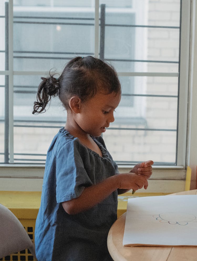 Ethnic Girl Drawing Near Window