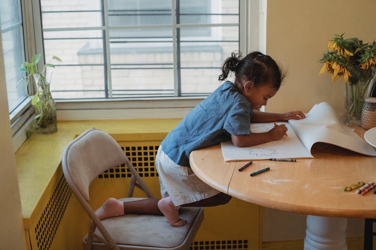 Concentrated Child Drawing At Table