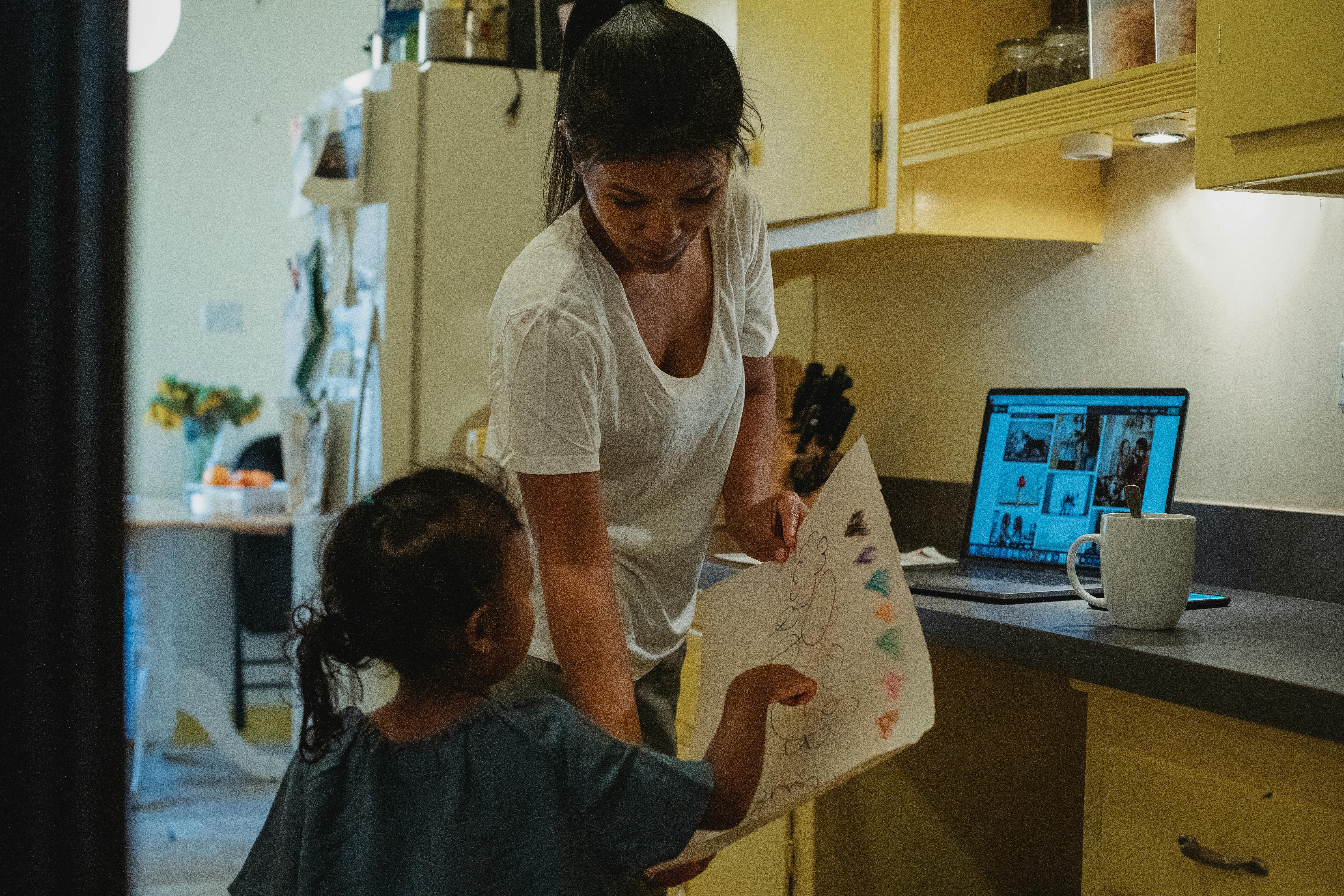 asian mother looking at picture with daughter
