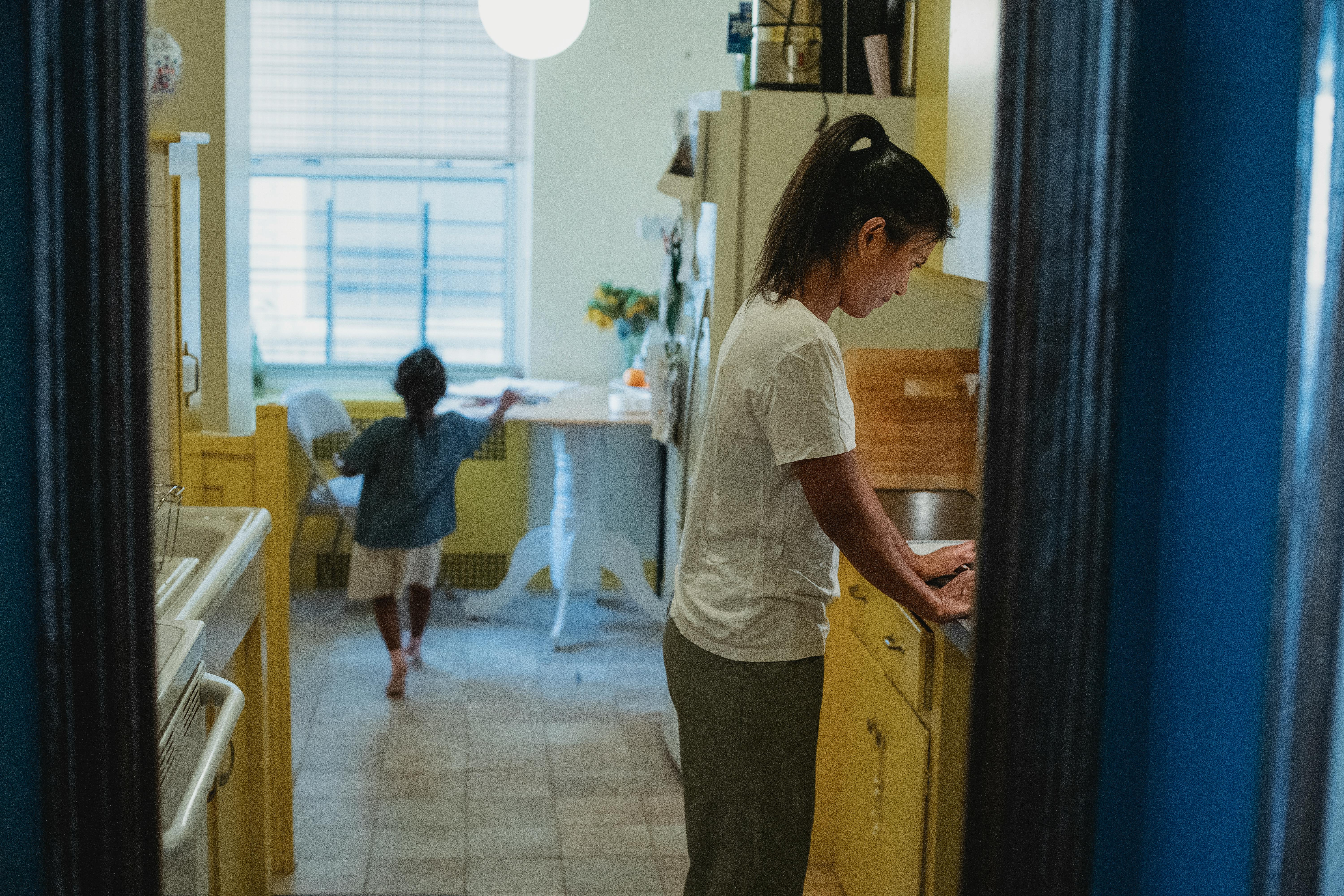 asian mother and daughter in kitchen with blue doorway