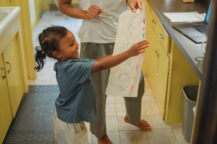 Cheerful Asian Daughter Showing Drawing To Crop Mother