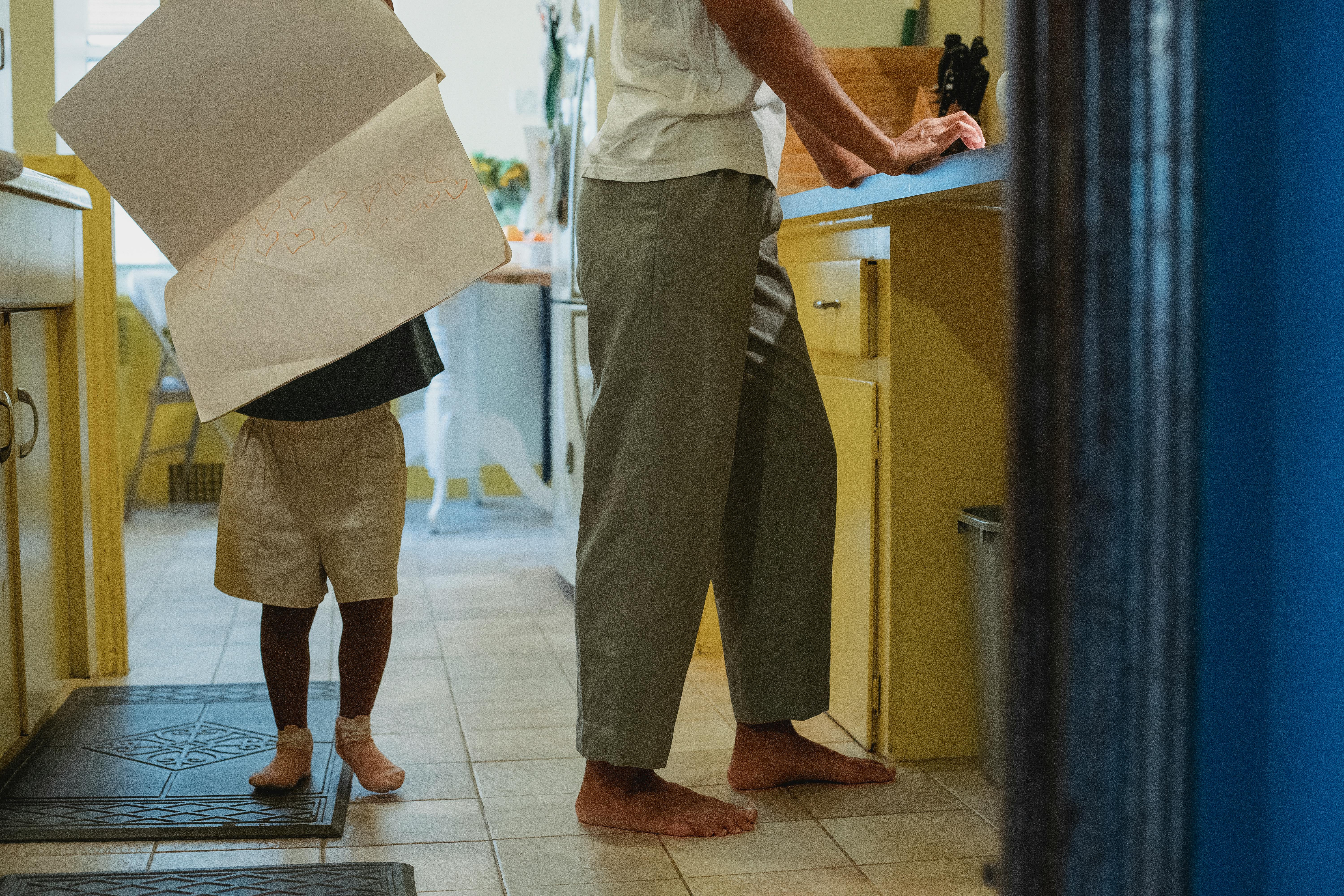 crop mother and unrecognizable daughter in kitchen