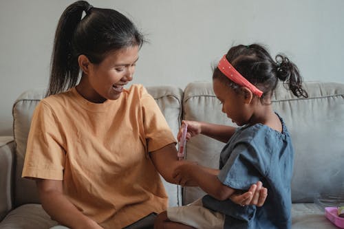 Madre E Hija étnicas Jugando Con Jeringa De Juguete