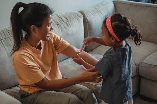 周末，女儿在客厅玩游戏时用假注射器向亚洲母亲注射的侧视图