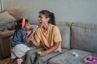 母女俩在舒适的客厅沙发上玩玩具，这是一个快乐的时刻