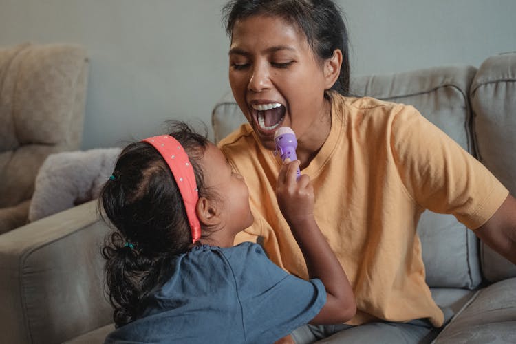 Happy Ethnic Mother With Opened Mouth Playing Doctor With Daughter