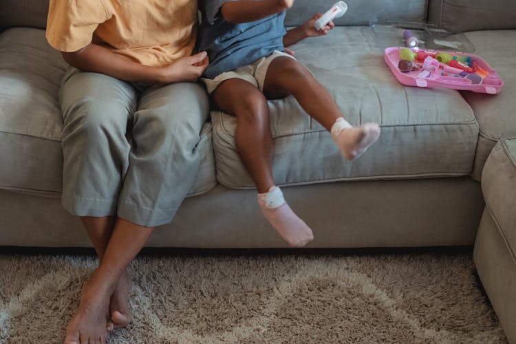 Ethnic Mother And Daughter Sitting On Sofa