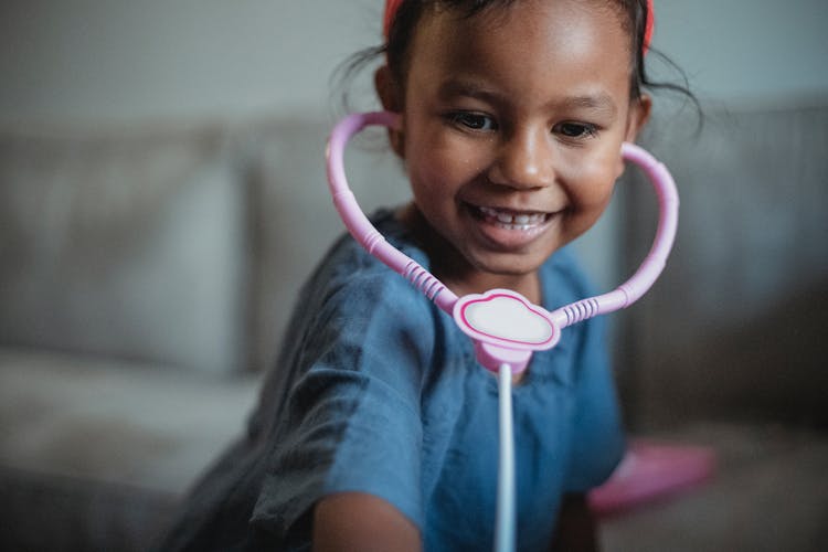 Playful Asian Girl With Pink Toy Stethoscope