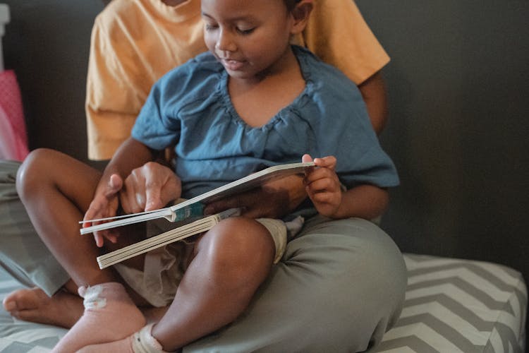 Crop Asian Mother With Daughter Reading Tale