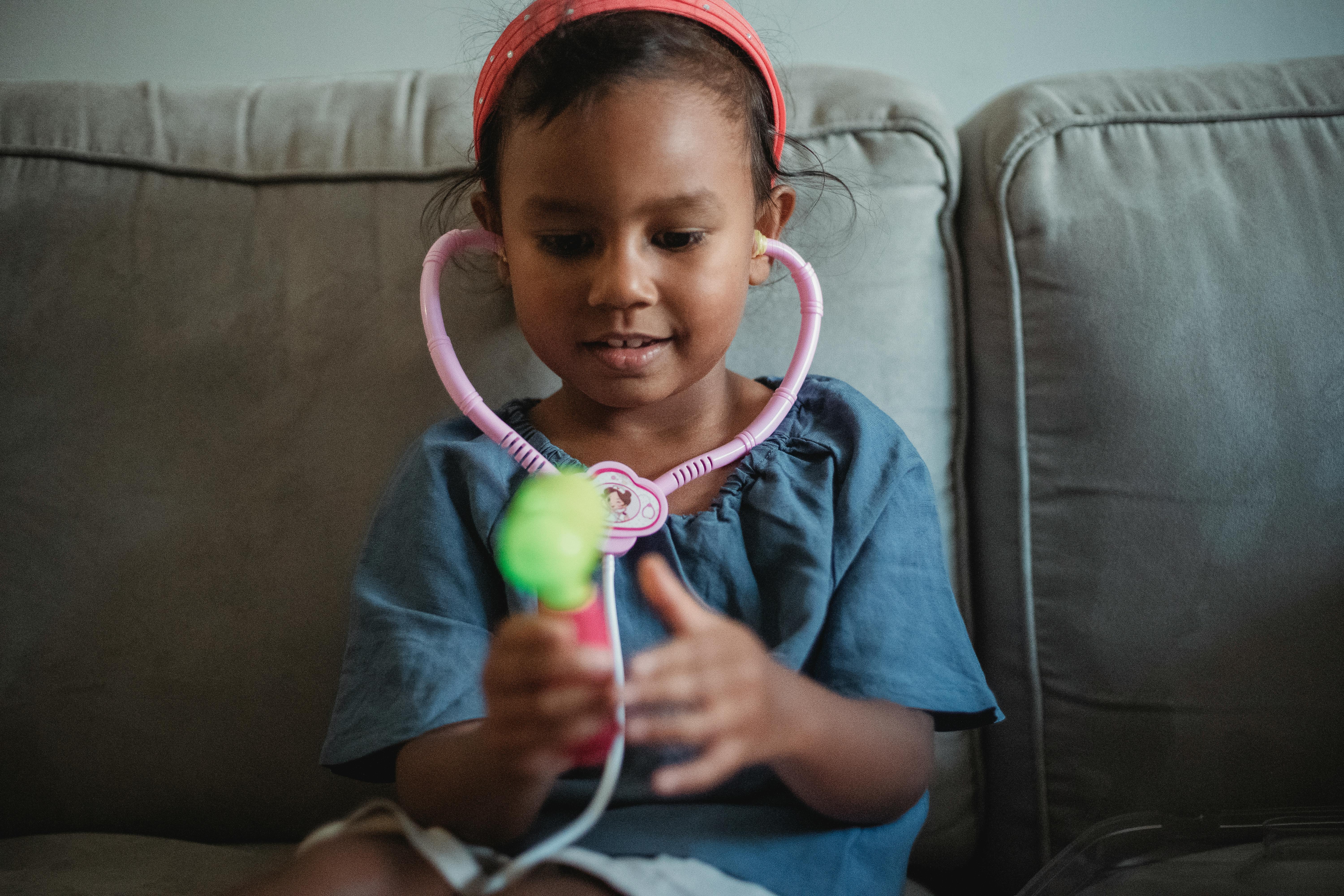 cheerful asian girl playing with stethoscope