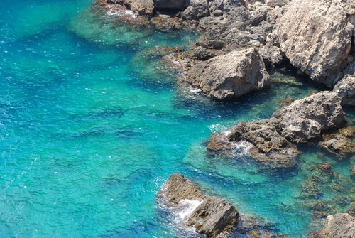Free A stunning aerial view of turquoise blue waters and rocky coastlines, perfect for travel themes. Stock Photo