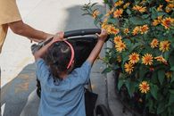 夏日里，一个孩子和母亲沿着鲜花成荫的人行道漫步