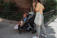 Ethnic mother and daughter walking on street