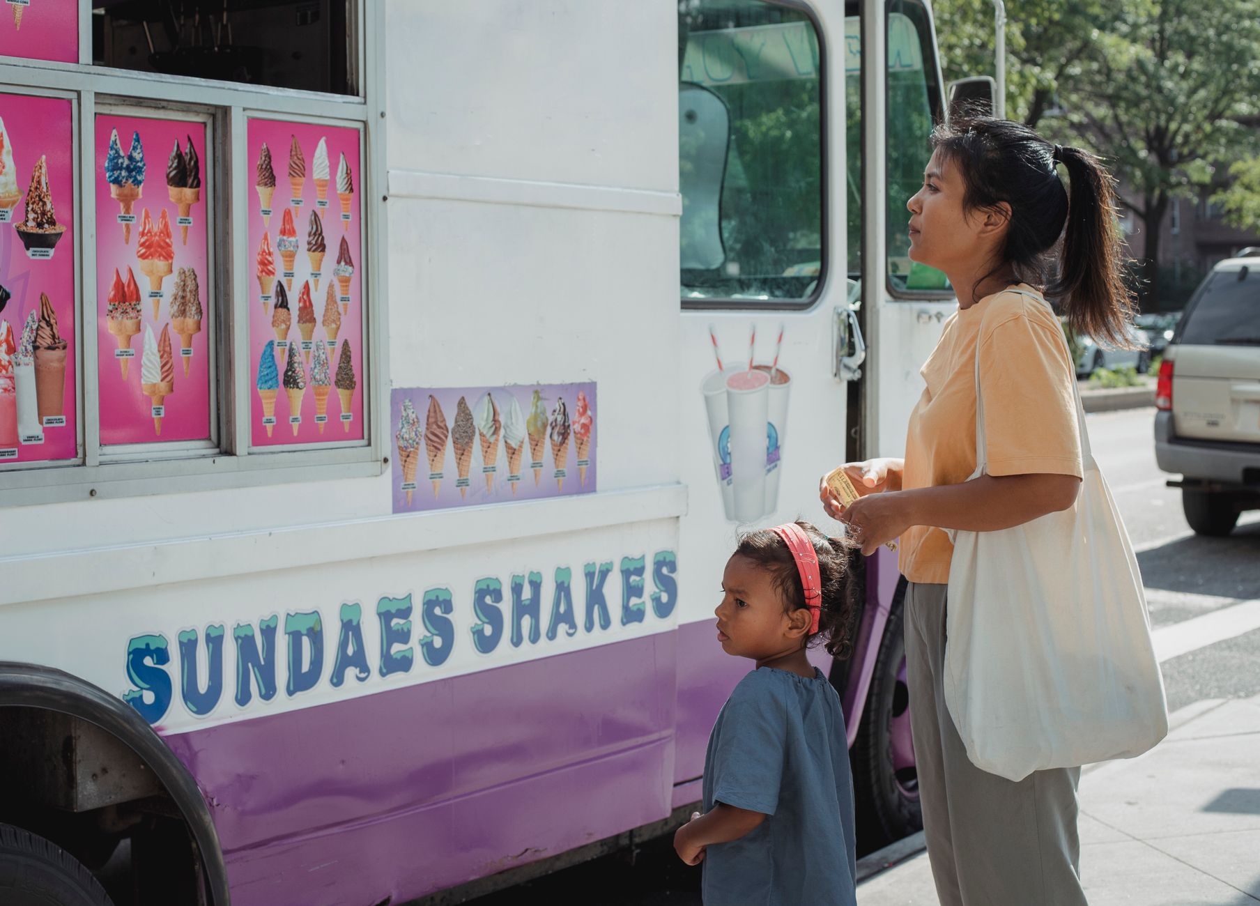 Mother and daughter choosing desserts near a food truck