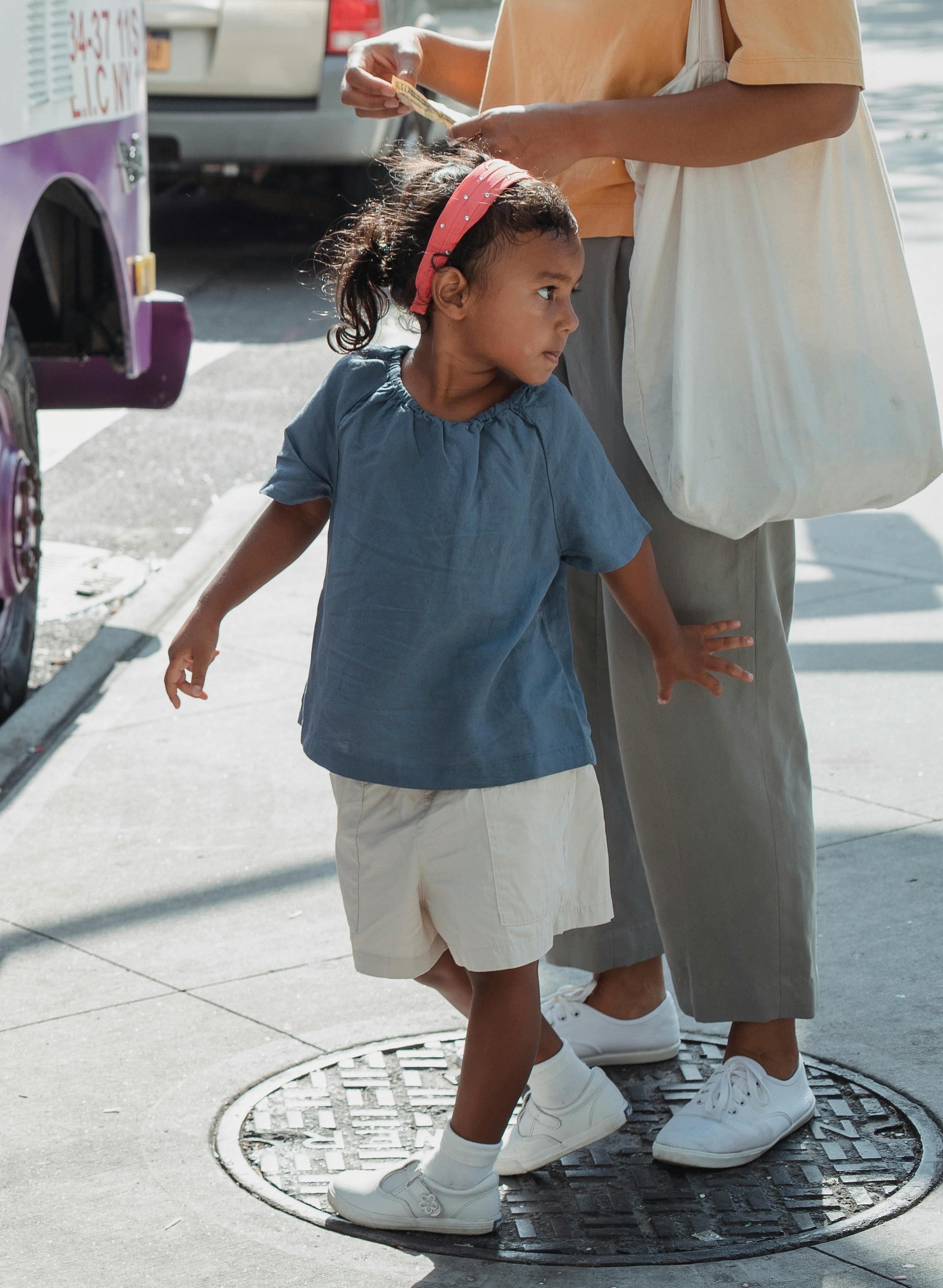 cute little asian girl near mother on street