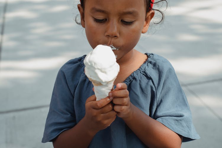 Asian Girl Eating Ice Cream On Street