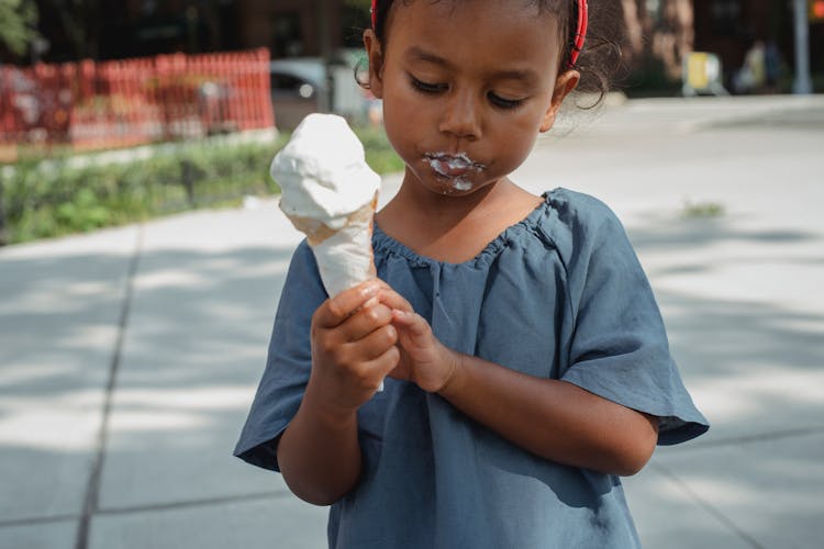 Asian Girl With Dirty Mouth Eating Ice Cream On Street