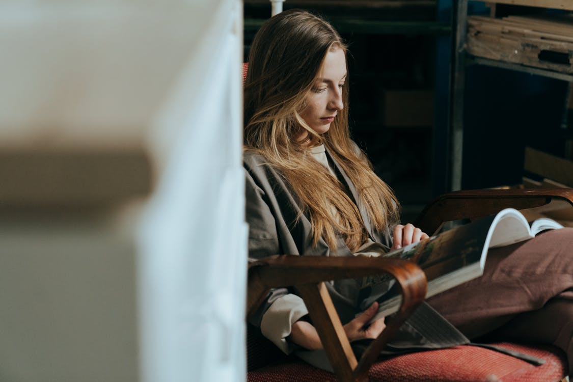 Free Woman in Black Jacket Sitting on Brown Wooden Chair Stock Photo