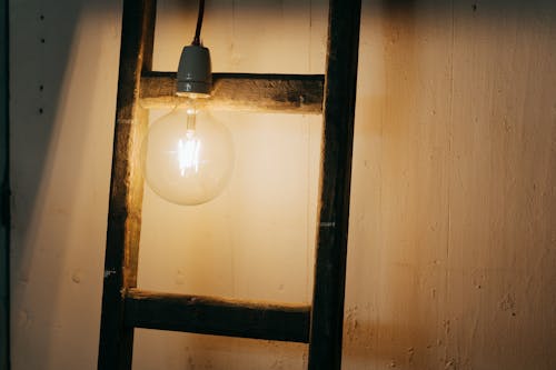 White Light Bulb Turned on Near Brown Wooden Frame