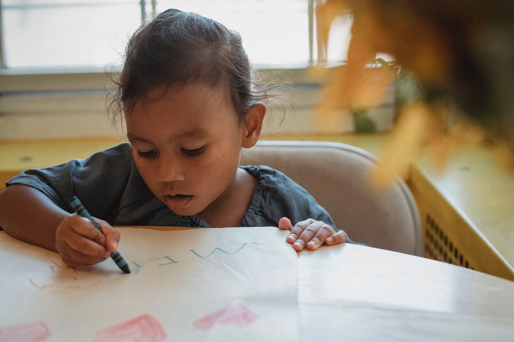 A child drawing quietly at a table