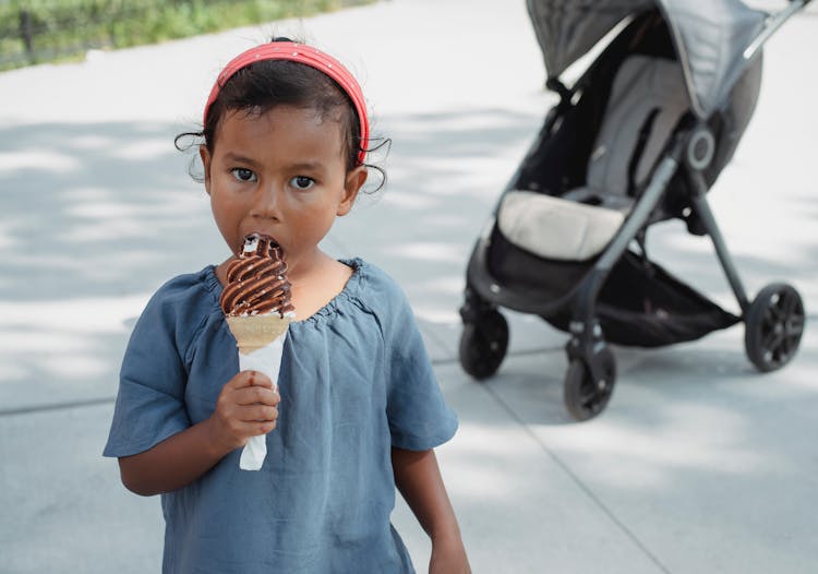 Adorable Little Girl Biting Ice Cream