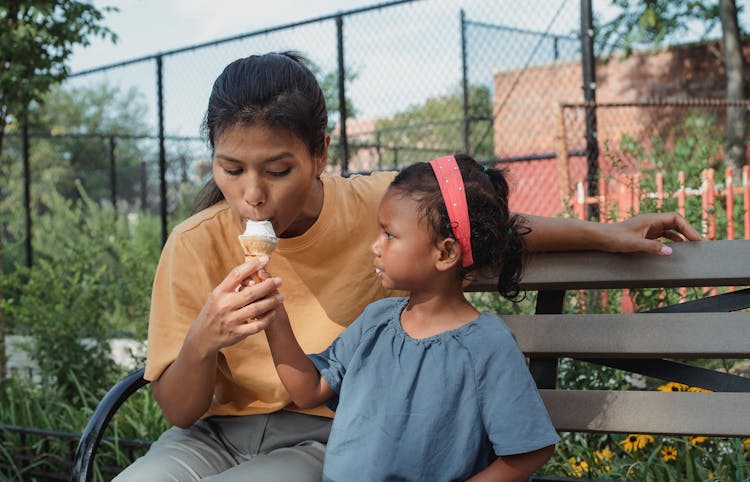 Mom And Daughter With Ice Cream In Park