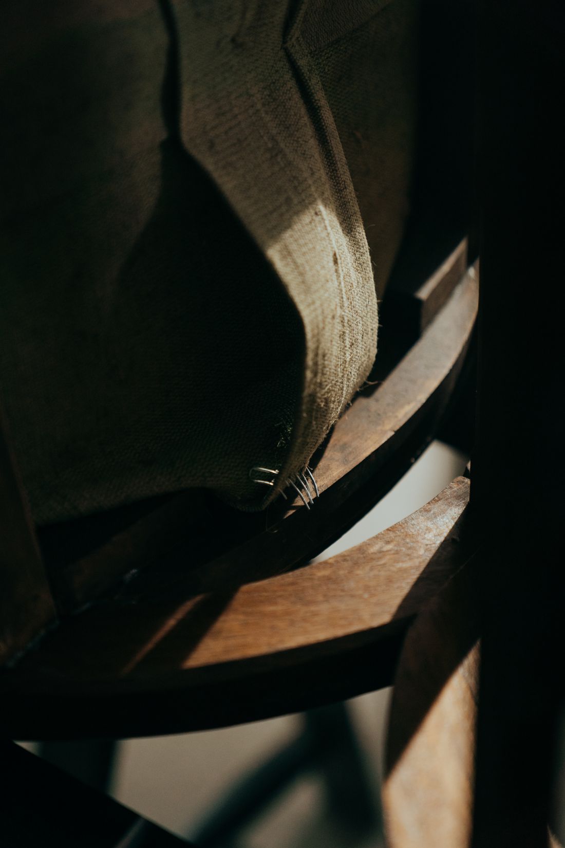 Détail de bois sculpté et de tissu sur un siège ancien en restauration