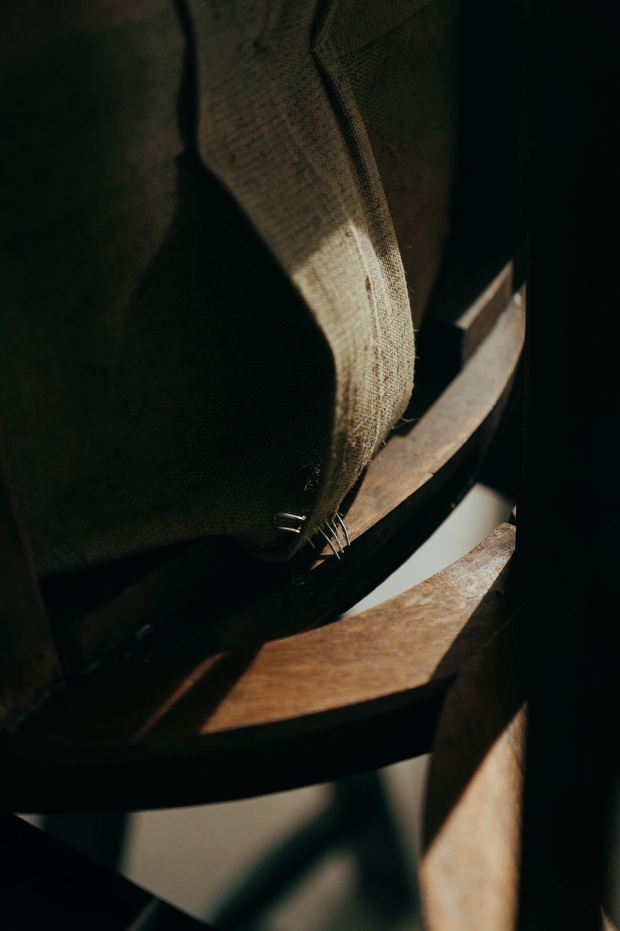 Gros plan sur la finition d’un fauteuil ancien en bois et tissu