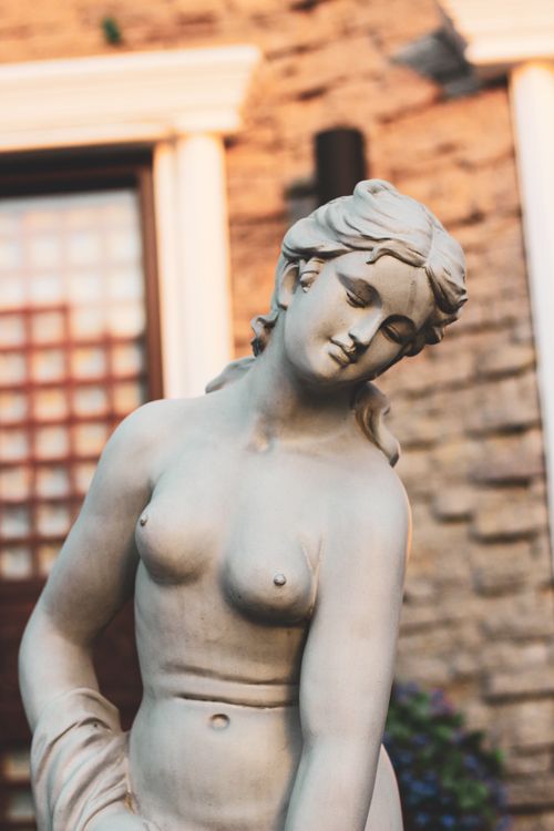 Free Close-up of a classical stone sculpture of a woman with a serene expression. Stock Photo