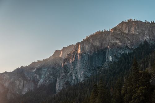 Free Stunning view of Yosemite Valley cliffs with conifer trees at dusk, showcasing nature's beauty. Stock Photo