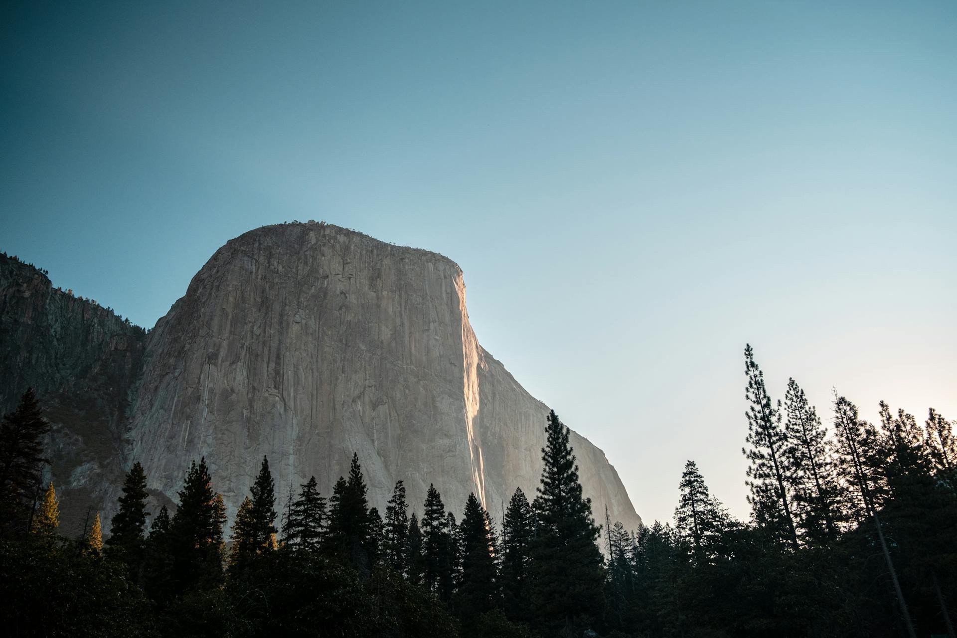 Breathtaking view of El Capitan in Yosemite Valley under a clear sky during sunset.