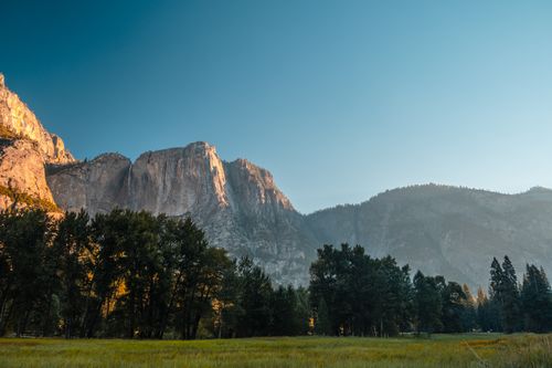 Free Breathtaking sunrise view of Yosemite Valley cliffs and lush forest landscape. Stock Photo