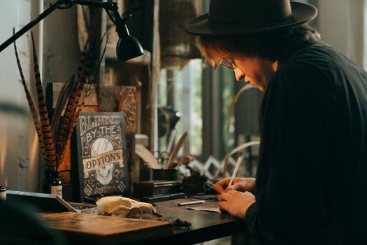 一个男人在充满艺术元素和柔和灯光的老式工作区里写作