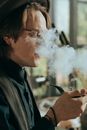 一位时尚男士在室内抽着烟斗的肖像，散发着复古的气息