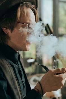 一位时尚男士在室内抽着烟斗的肖像，散发着复古的气息