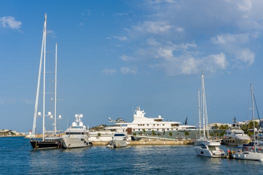 Stunning view of luxury yachts docked in the harbor of Ibiza, showcasing nautical elegance and serene waters.