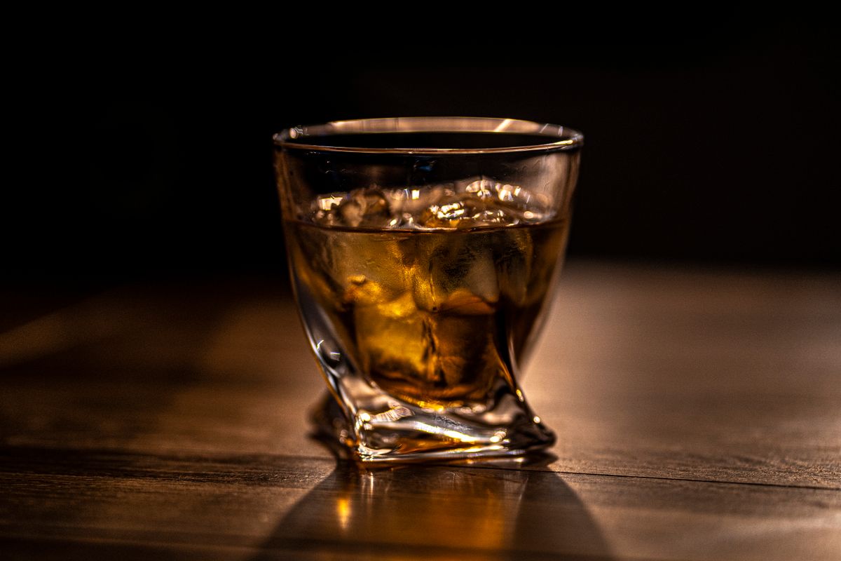Pahar de whisky cu gheata, in lumina calda